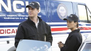 Timothy McGee and Ziva David standing near NCIS van