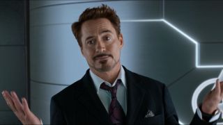 Robert Downey Jr throws up his hands in surprise while smirking in Spider-Man Homecoming.